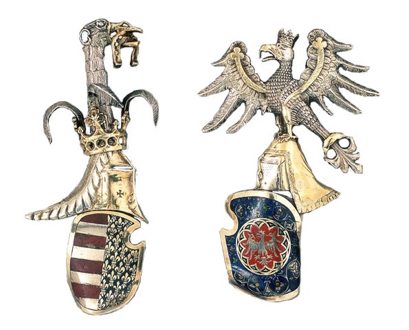 Zapinki z herbami Królestwa Polskiego i Węgier z lat około 1340-1380 Źródło: Medieval Master, Zapinki z herbami Królestwa Polskiego i Węgier z lat około 1340-1380, fotografia, domena publiczna.