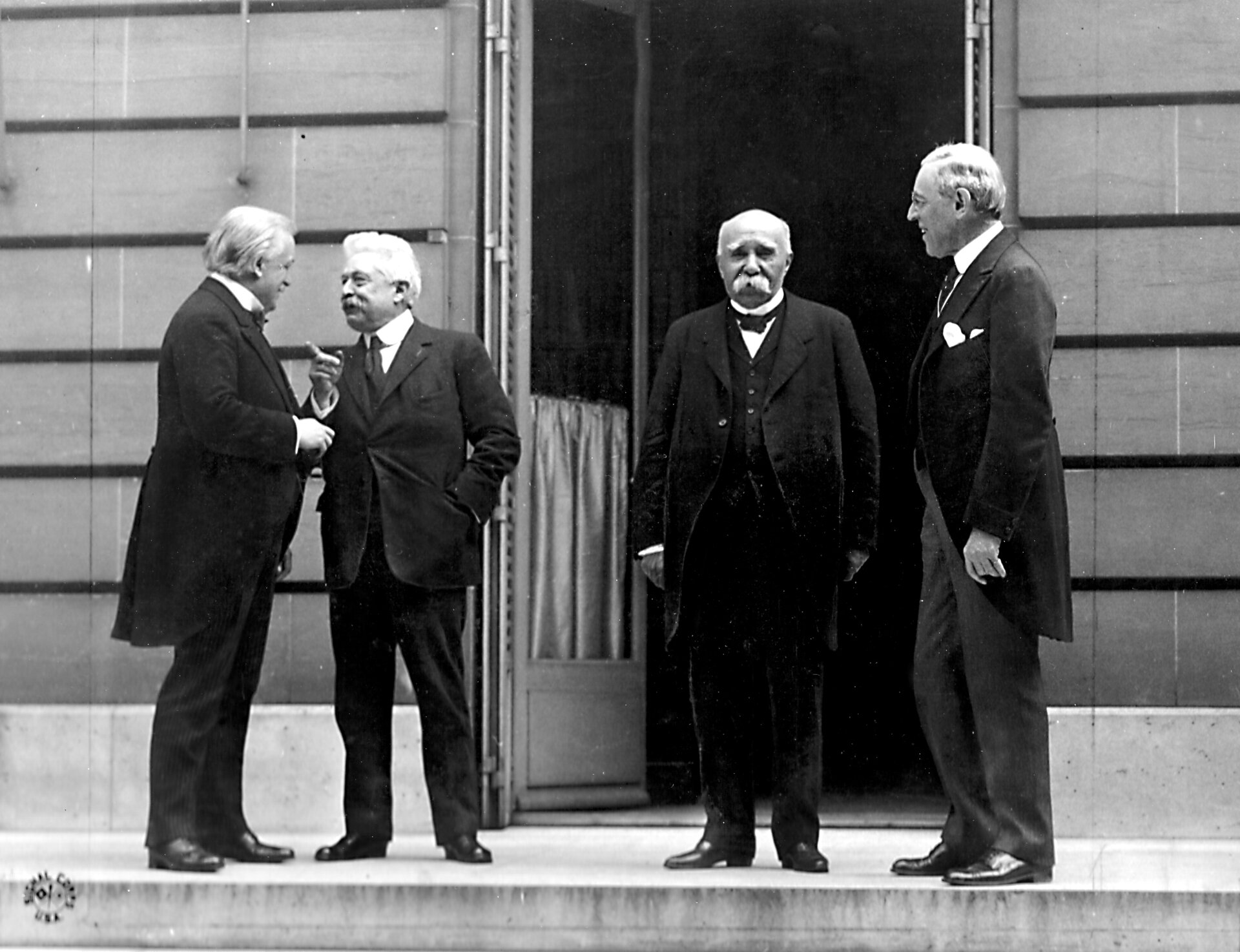 Od lewej: David Lloyd George, Vittorio Emanuele Orlando (Włochy), Georges Clemenceau, Thomas Woodrow Wilson Źródło: Od lewej: David Lloyd George, Vittorio Emanuele Orlando (Włochy), Georges Clemenceau, Thomas Woodrow Wilson, Fotografia, domena publiczna.