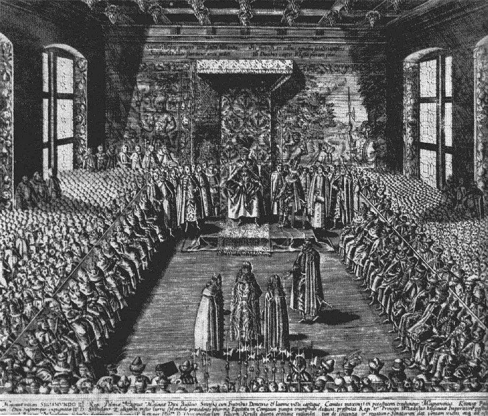Posiedzenie sejmu w sali senatu na Zamku Królewskim w Warszawie według ryciny z pocz. XVII w. Druga rycina pokazuje prezentację pojmanego cara Rosji Wasyla Szujskiego w 1611 r. przed sejmem w izbie senackiej Zamku Królewskiego. Posiedzenie sejmu w sali senatu na Zamku Królewskim w Warszawie według ryciny z pocz. XVII w. Druga rycina pokazuje prezentację pojmanego cara Rosji Wasyla Szujskiego w 1611 r. przed sejmem w izbie senackiej Zamku Królewskiego. Źródło: Tomasz Makowski, 1613, Rycina, Biblioteka Narodowa, domena publiczna.