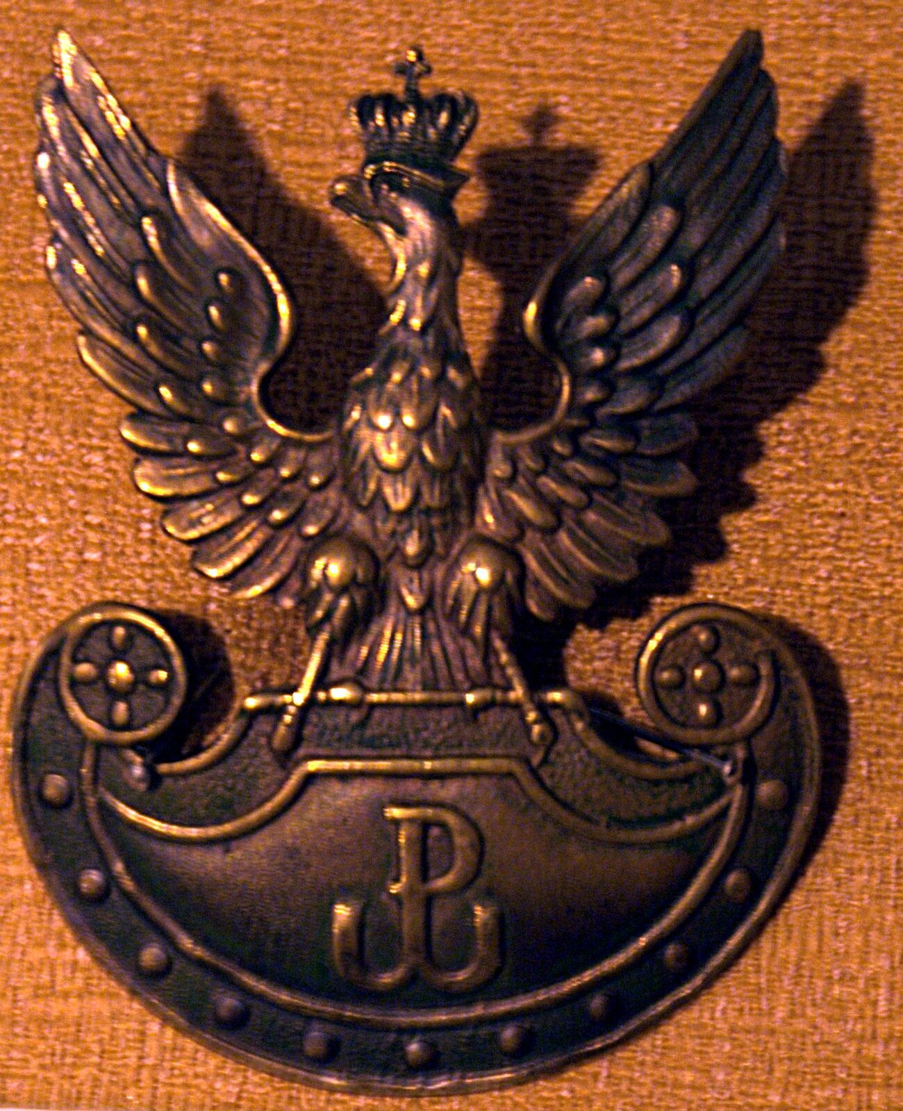 Mosiężny orzełek Armii Krajowej, bity w latach 1942-45 Mosiężny orzełek Armii Krajowej, bity w latach 1942-45 Źródło: Muzeum Hymnu Narodowego w Będominie, licencja: CC BY-ND 1.0.