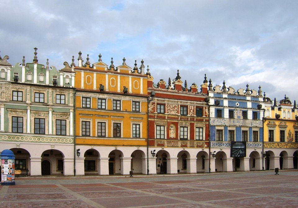 Kamienice ormiańskie w Rynku w Zamościu. Kamienica „ormiańska” nr 28 (ciemnożółta) to kamienica Rudomiczowska. Należy ona do Bazylego Rudomicza, prawnika, profesora Akademii Zamojskiej, wybitnego patrycjusza zamojskiego. Kamienice ormiańskie w Rynku w Zamościu. Kamienica „ormiańska” nr 28 (ciemnożółta) to kamienica Rudomiczowska. Należy ona do Bazylego Rudomicza, prawnika, profesora Akademii Zamojskiej, wybitnego patrycjusza zamojskiego. Źródło: MaKa, Wikimedia Commons, licencja: CC BY-SA 2.5.