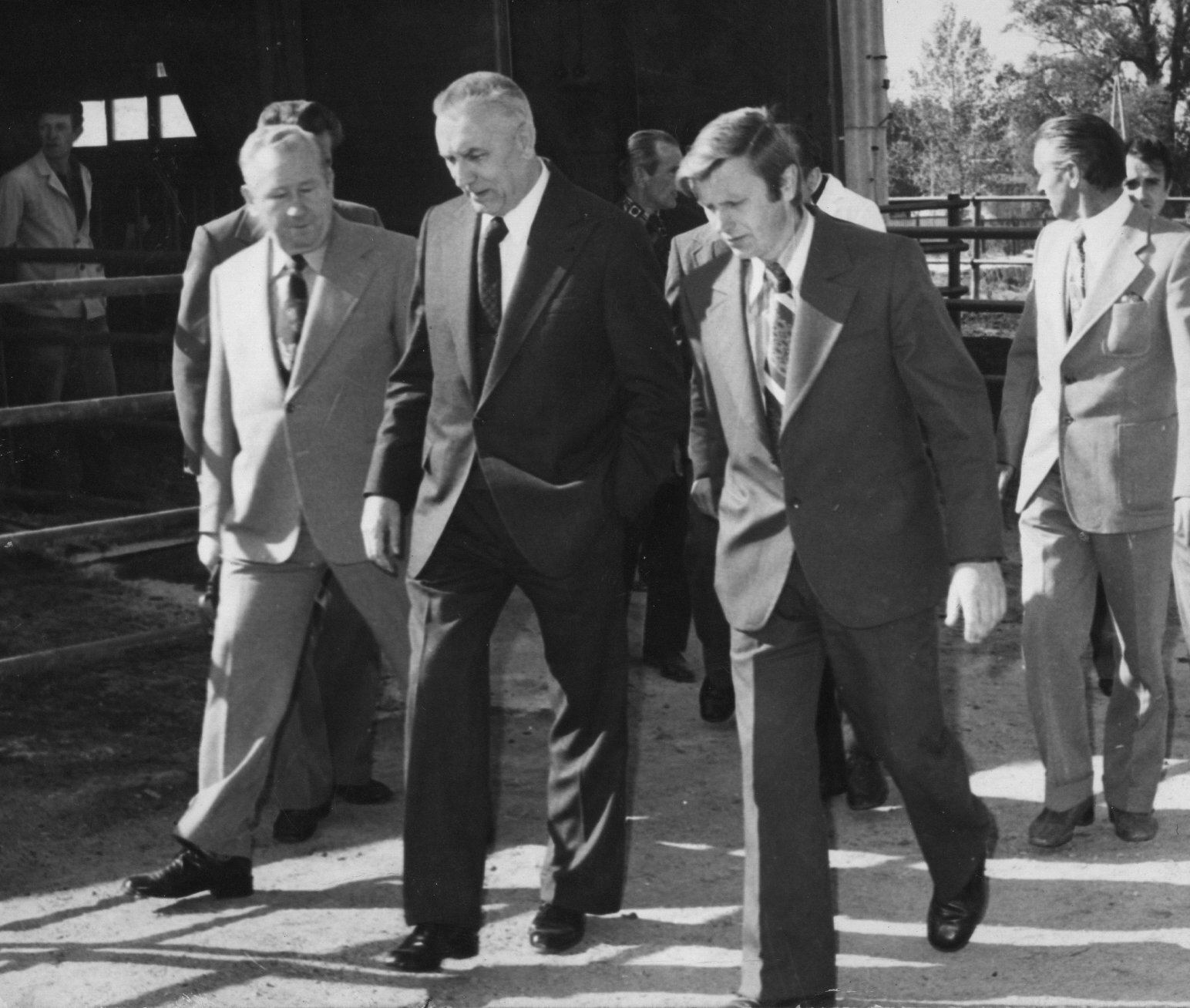 Fotografia przedstawia Edwarda Gierka spacerującego w otoczeniu swoich doradców. Panowie rozmawiają.