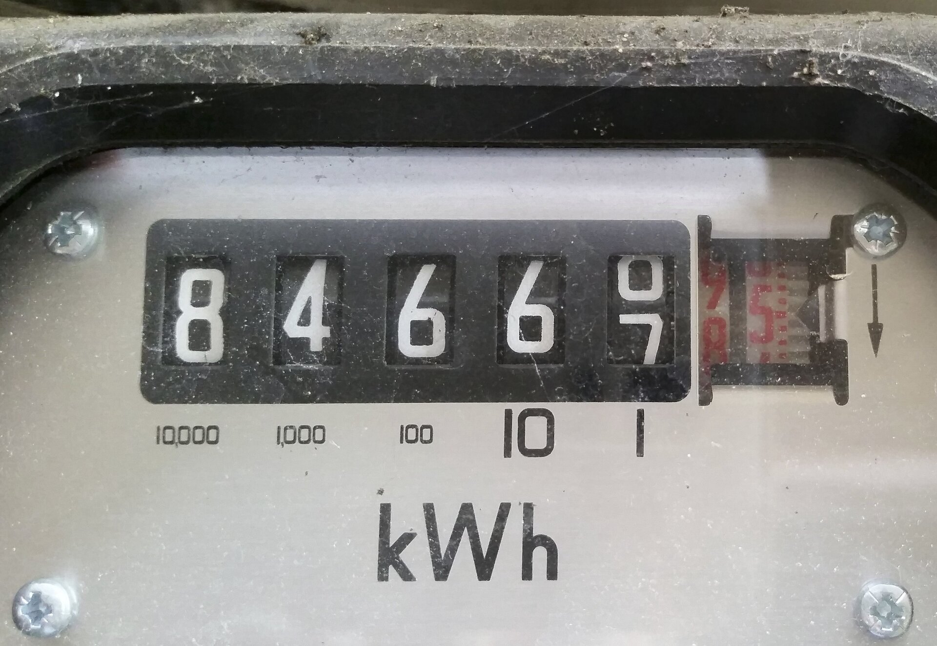 Zdjęcie przedstawia zbliżenie fragmentu przedniego panelu licznika energii elektrycznej, a dokładniej tarczę licznika wskazującą wartość 84667,5 oraz symbol jednostki kWh poniżej.