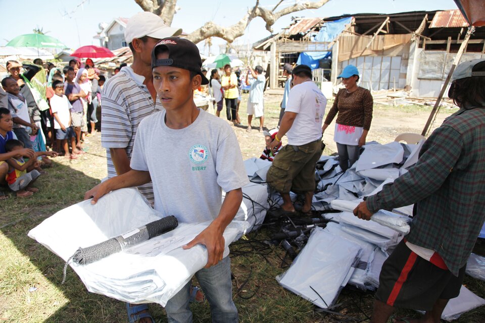 Na zdjęciu kolejka osób w oczekiwaniu na pomoc humanitarną. Na pierwszym planie osoby, które otrzymały już namioty.