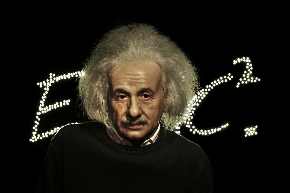 Zdjęcie przedstawia podobiznę Alberta Einsteina, a dokładniej mówiąc przedstawiającą go figurę w gabinecie figur naturalnych Madame Tussaud na tle ułożonego z licznych punktowych świateł wzoru E równa się m c kwadrat. Uczony przedstawiony w wieku średnim ukazany jest od ramion w górę, spogląda nieco w bok z zamyślonym wyrazem twarzy.