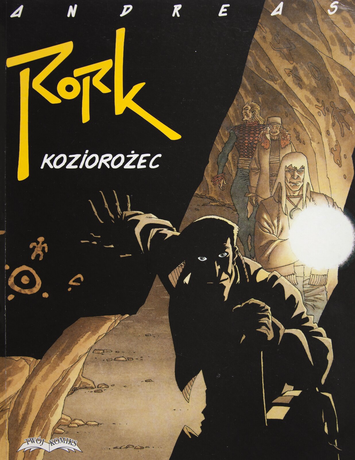 Ilustracja przedstawia okładkę do komiksu Andreasa „Rork. Koziorożec”. Ukazuje grupę osób przemierzających podziemny korytarz jaskini. Postać na pierwszym planie ukryta jest w ciemności. Światło pada na mężczyznę z tyłu, rozświetlając jedynie fragmenty ubrania i twarzy. Prawą ręką daje znak do zatrzymania się osób idących za nim. Przestrzeń w tle jest oświetlona lampą przez jedną z trzech idących dalej osób. Trzy te postacie idą jedna za drugą. Mężczyzna na końcu rozgląda się. Lewa strona okładki jest czarną, zaciemnioną częścią skały. Znajdują się na niej namalowane znaki, a powyżej zostały zamieszczone: nazwisko autora i tytuł komiksu.