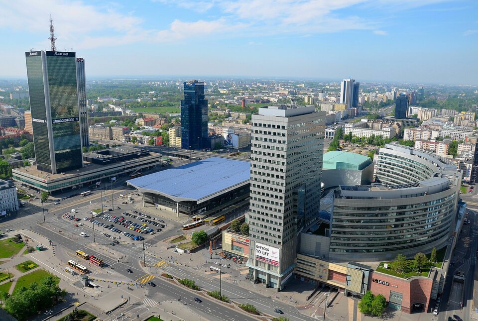 Na zdjęciu nowoczesna zabudowa usługowa i biurowa. Wysokie budynki, dworzec, parkingi.