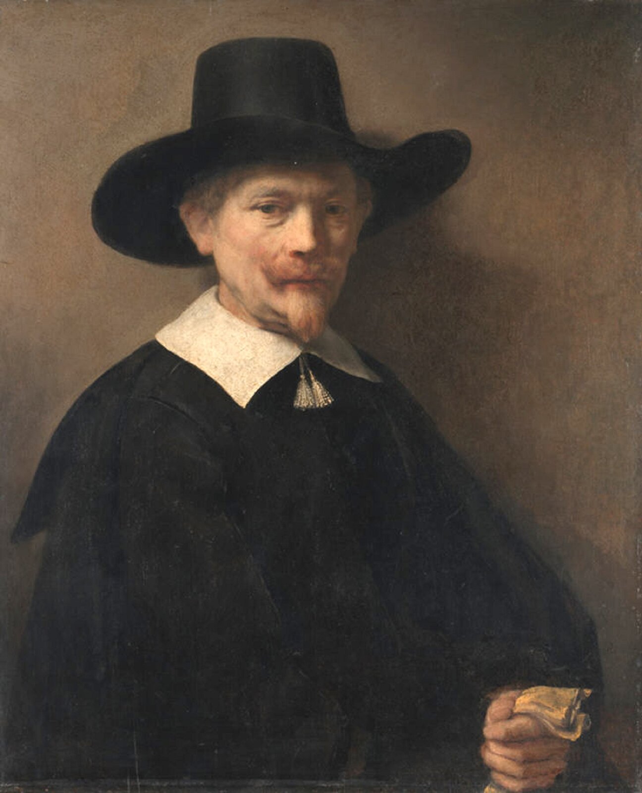 Ilustracja przedstawia obraz olejny „Portret mężczyzny z rękawiczkami” autorstwa Rembrandta van Rijn. Realistyczny portret ukazuje starszego mężczyznę w czarnym kapeluszu z dużym rondem oraz ciemnym płaszczu z narzuconą na ramiona peleryną i białym kołnierzem. Pomiędzy dwoma częściami kołnierza zwisają dwa frędzelki. Mężczyzna ma jasne wąsy i bródkę. Na jego twarzy rysują się powaga i zamyślenie. Wzrok skierowany jest lekko w dół. Ważnym elementem malowidła jest światło które miękko wydobywa twarz postaci z półmroku. Kołnierz i jasna twarz postaci stanowią silną dominantę obrazu. Postać trzyma w lewej ręce blado-żółtą rękawiczkę. Statyczna kompozycja, jednolita beżowa tonacja oraz miękkie światło – te wszystkie elementy podkreślają powagę przedstawionej na obrazie postaci.