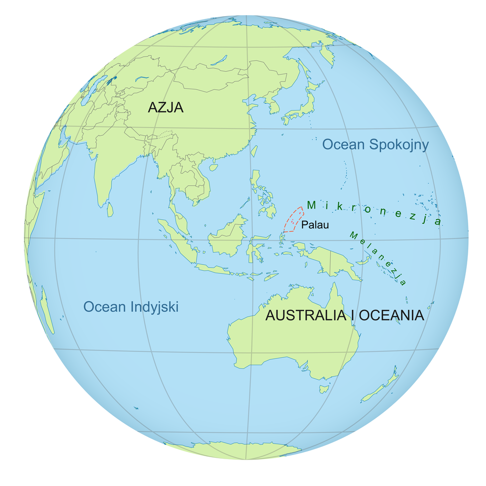 Ilustracja przedstawia kulę ziemską. Na powierzchni kuli zaznaczone są południki i równoleżniki. Na półkuli południowej mapa Australii i Oceanii. Powyżej, wzdłuż linii równika, małe wysepki Mikronezji i Melanezji. Mały obszar Republiki Palau zaznaczony w formie czerwonego pionowego trapezu. Palau znajduje się nieco powyżej równika Półkula północna, to duży obszar Azji. Niebieski kolor wskazuje Ocean Indyjski na południowej półkuli oraz Ocean Spokojny na półkuli północnej.
