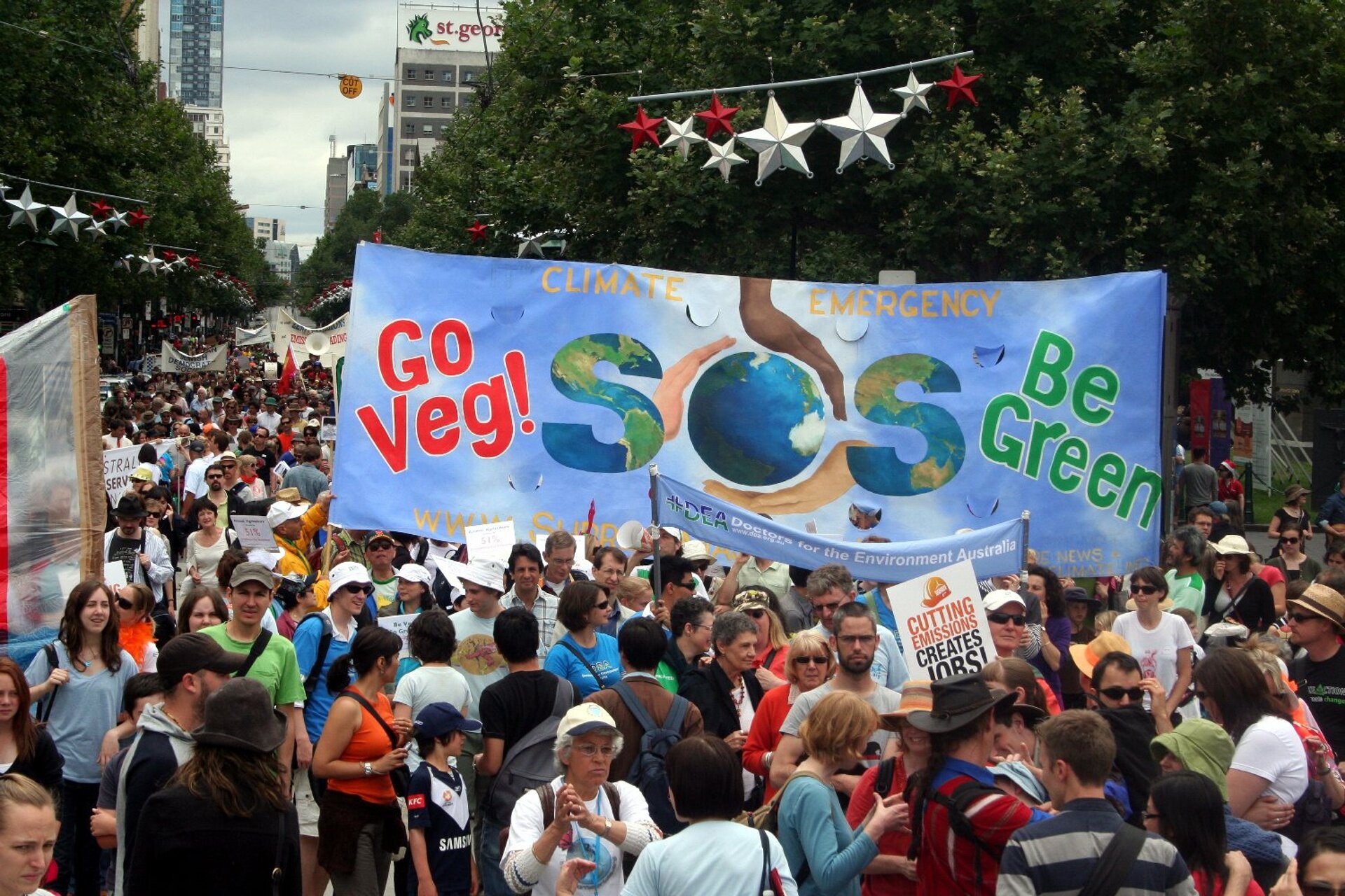 Na zdjęciu manifestacja w Melbourne w Australii w obronie klimatu. Manifestanci domagają się większej dbałości od polityków o klimat na Ziemi i doprowadzenie do zmniejszenia emisji dwutlenku węgla. Na zdjęciu wielki, kolorowy tłum ludzi maszerujący ulicą. Ludzie trzymają transparenty.