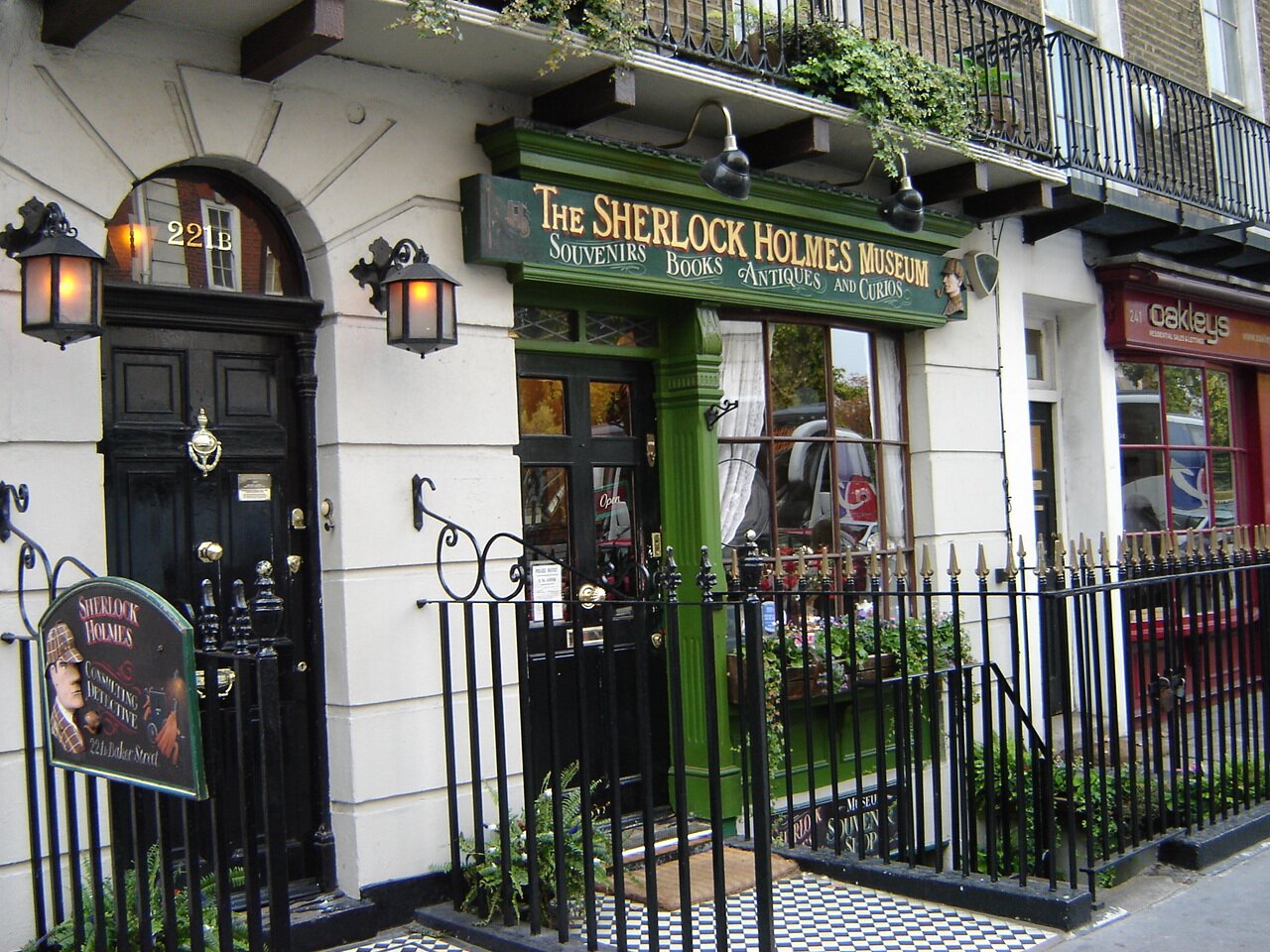 Chociaż Sherlock Holmes jest postacią fikcyjną, jego twórca ulokował mieszkanie bohatera w Londynie pod realnie istniejącym adresem: Baker Street 221B. Chociaż Sherlock Holmes jest postacią fikcyjną, jego twórca ulokował mieszkanie bohatera w Londynie pod realnie istniejącym adresem: Baker Street 221B. Źródło: Jordan1972, fotografia barwna, domena publiczna.