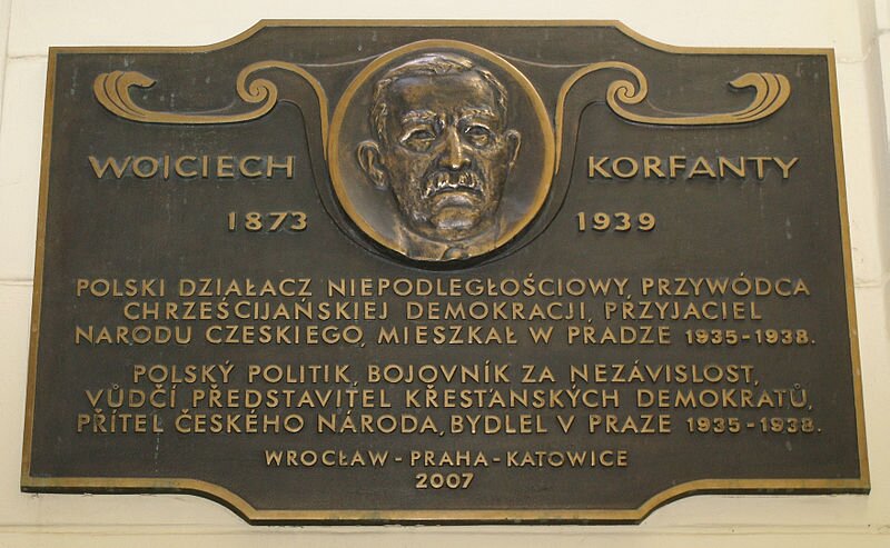 Miedziana tablica pamiątkowa ku czci W. Korfantego w Pradze czeskiej. Oprócz podobizny Korfantego napis: „Wojciech Korfanty. 1873–1939. Polski działacz niepodległościowy. Przywódca chrześcijańskiej demokracji, przyjaciel narodu czeskiego, mieszkał w Pradze 1935–1938”. Oraz to samo po czesku. „Wrocław–Praha–Katowice 2007” Źródło: Luděk Kovář, Miedziana tablica pamiątkowa ku czci W. Korfantego w Pradze czeskiej. Oprócz podobizny Korfantego napis: „Wojciech Korfanty. 1873–1939. Polski działacz niepodległościowy. Przywódca chrześcijańskiej demokracji, przyjaciel narodu czeskiego, mieszkał w Pradze 1935–1938”. Oraz to samo po czesku. „Wrocław–Praha–Katowice 2007”, licencja: CC BY-SA 3.0.