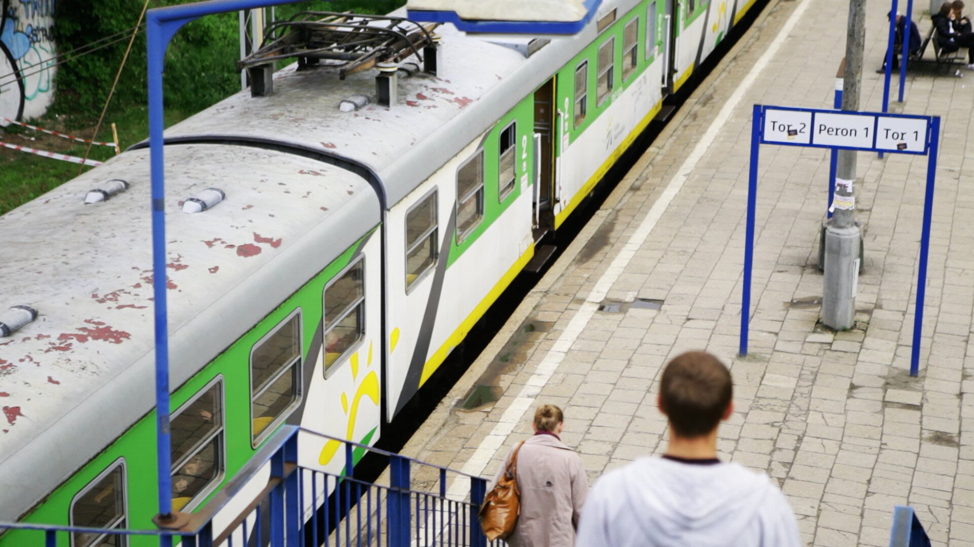 Zdjęcie pociągu osobowego stojącego na stacji kolejowej.