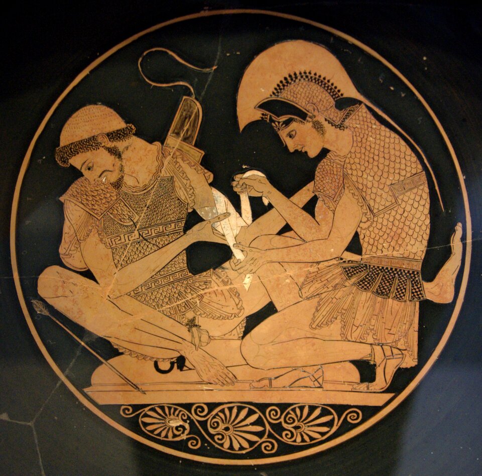 Achilles opatrujący rannego Patroklosa Scena wykonana we wnętrzu czerwonofigurowej czary z Vulci Źródło: Sosias, Achilles opatrujący rannego Patroklosa, ok. 500 r. p.n.e., British Museum, Londyn, domena publiczna.